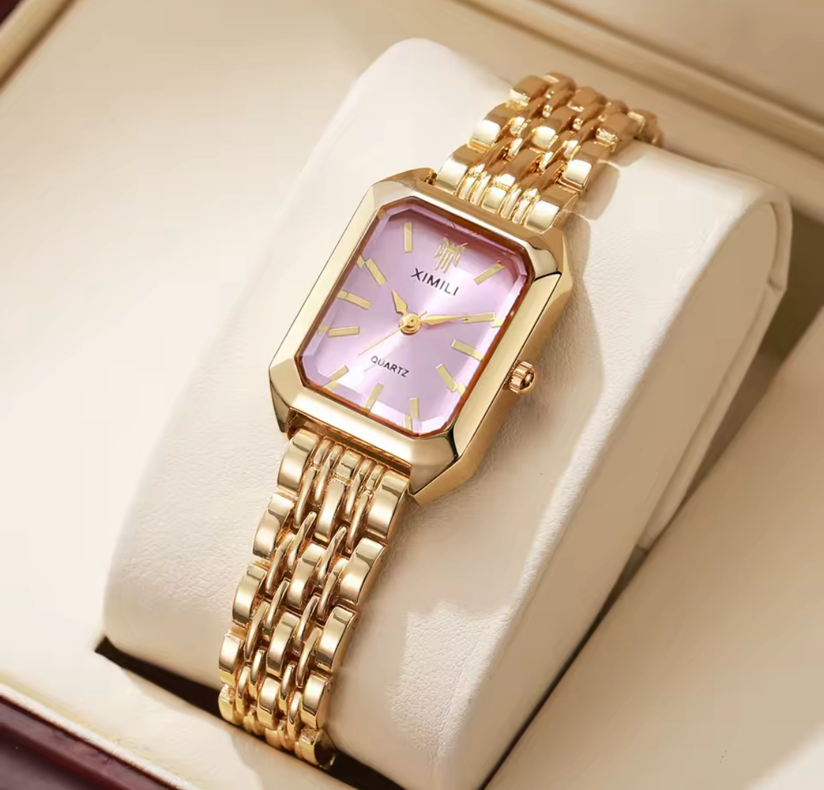Pink dial XIMILI watch on a cream cushion